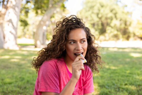 Mujer comiendo barra de proteína