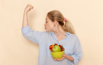 frontal joven mujer camisa sosteniendo plato frutas flexionando pared crema fruta modelo mujer pose