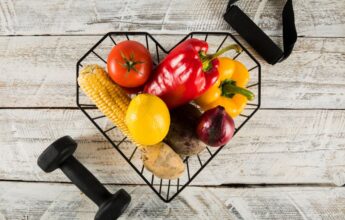 productos saludables en cesta negra con pesas de gimnasio