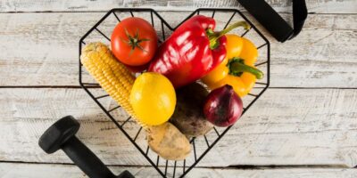 productos saludables en cesta negra con pesas de gimnasio