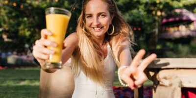 Mujer de pelo largo bebiendo batido en el parque