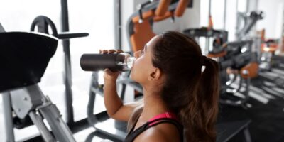 mujer bebiendo en el gimnasio