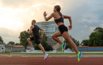 Hombre y mujer corriendo en la pista de atletismo