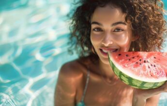 mujer comiendo sandia en la piscina