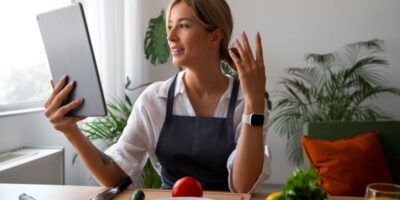 Chef femenina teniendo una videollamada mientras cocina