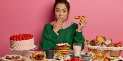 mujer comiendo exceso de dulces