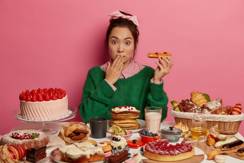 mujer comiendo exceso de dulces